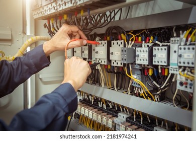 Electrical engineer using measuring equipment to checking electric current voltage at circuit breaker and cable wiring system , Electrical service concept . - Shutterstock ID 2181974241