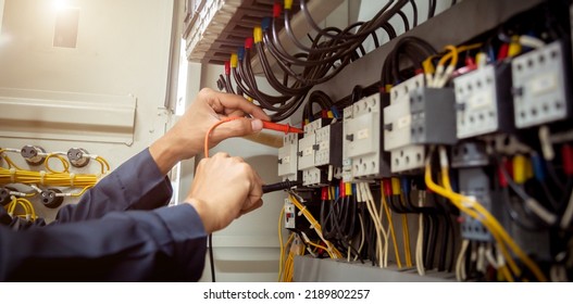 Electrical engineer using measuring equipment to checking electric current voltage at circuit breaker and cable wiring system , Electrical service concept . - Shutterstock ID 2189802257