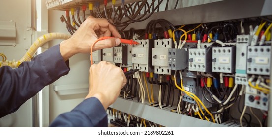 Electrical engineer using measuring equipment to checking electric current voltage at circuit breaker and cable wiring system , Electrical service concept . - Shutterstock ID 2189802261