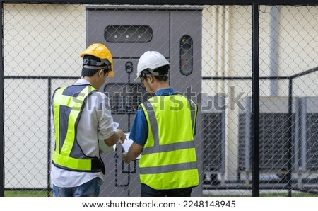 Electrical engineer working in control room. Electrical engineer man checking Power Distribution Cabinet in the control room