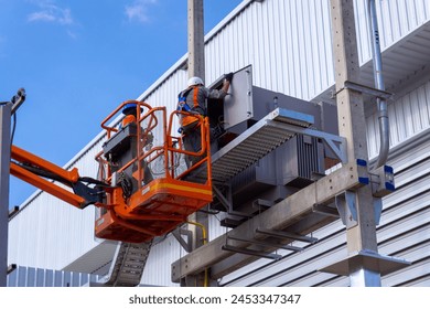 Electrical engineer working on boom lift for inspection power transformer 
