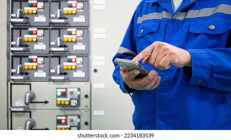 Electrical engineer working in substation building checking electrical current and voltage sine wave  by Application in mobile phone, Energy industrial work concept and modern technology. - Powered by Shutterstock