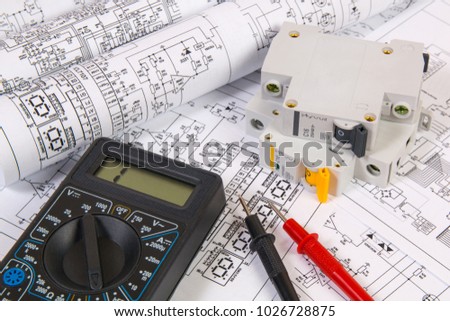 Electrical engineering drawings, modular circuit breaker and digital multimeter. Electrical network protection and switching.