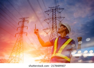 Electrical engineers standing holding walky talky and looking success poss with power line towers energy high voltage in sunset in the background, energy concept.
