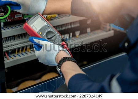 Electrical engineers using measuring them with a multimeter test electrical installations and wiring on protective relays.