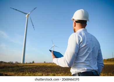 Electrical Engineers Working At Wind Turbine Power Generator Station With Laptop Computer