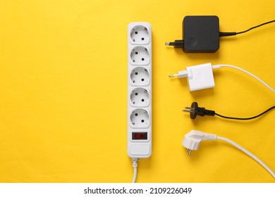 Electrical Extension cord with different plugs and adapters on yellow background. Top view. - Shutterstock ID 2109226049