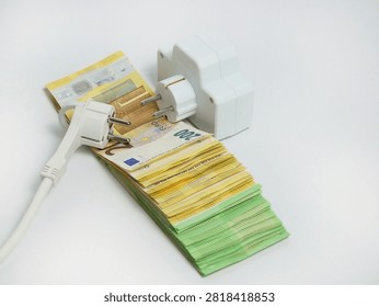 Electrical extension socket and power plug placed on euro banknotes, illustrating rising electricity prices, increasing energy costs, utility bills, inflation and household expenses in Europe.