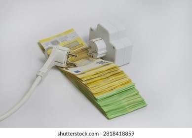 Electrical extension socket and power plug placed on euro banknotes, illustrating rising electricity prices, increasing energy costs, utility bills, inflation and household expenses in Europe.