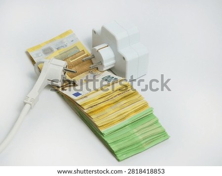 Electrical extension socket and power plug placed on euro banknotes, illustrating rising electricity prices, increasing energy costs, utility bills, inflation and household expenses in Europe.