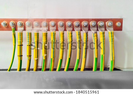 Electrical high voltage ground copper cables on wall. Grounding electric bar. Cables connected to electrical grounding bar. Ground industry for control system.