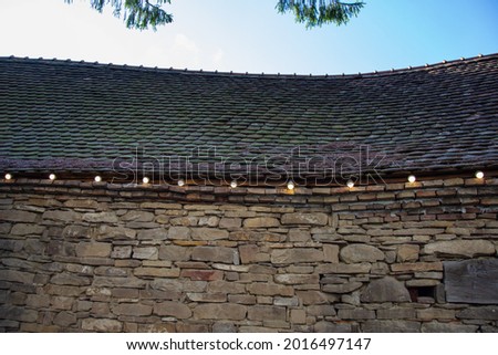 electrical installation with light bulbs on a stone wall at Evangelical Fortified Church Crit, Brasov, Romania 2019