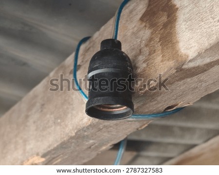 Electrical light bulb socket mounted on rustic wooden beam, vintage plastic lamp holder, indoor ceiling fixture installation, power wiring setup, home renovation project, design material, graphic resource, raw picture, editable image, unedited and natural look 