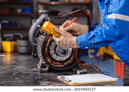 Electrical Maintenance Motor. Technician at Work measuring power meter with Electric motor in modern heavy EV car industry