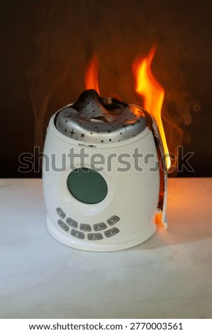 Electrical night projector overheating with flames and thick smoke showing dangerous device malfunction in home.