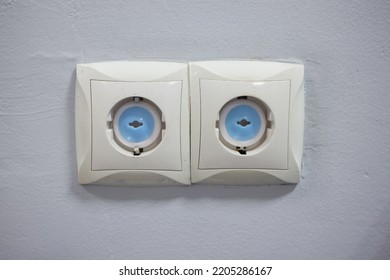 Electrical Outlet With Electricity Safety Cover To Prevent Child Electrocution. Baby Proofing Household Power Sockets With Plastic Plug Inserts.