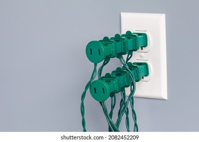 Electrical Outlet Overloaded With Christmas String Lights. Holiday Decoration Safety, Hazards And Fire Prevention Concept.