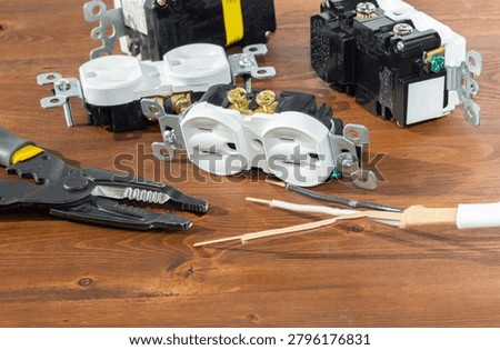 Electrical outlet, screwdriver and wire stripper tools on white background