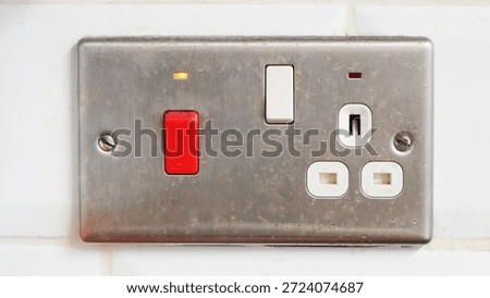 Electrical outlet and switch panel features red button and indicator light for functionality