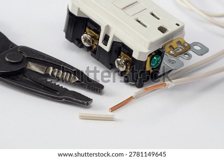 Electrical outlets, screwdriver, and wire stripper tools on a white background, illustrating electrical installation, and DIY projects.