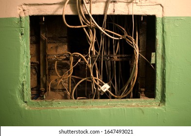 Electrical Panel On The Wall Of The House. Electric Cables Stick Out From The Electric Panel On The Old Green Brick Wall Of The Old House.Electric Shield, Electrical Wiring In Old House, Power Supply 