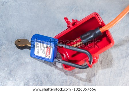 electrical plug lockout device secured with padlock and key for locking out electrical plugs 