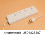 Electrical plug in outlet socket at home, Electrical plug in outlet socket at home, Energy efficiency concept, Power strip with extension cord on beige background, top view.