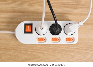 Electrical plug in outlet socket at home isolated on on wooden table, Outlet, Electric Plug, Power Cable, a power button and a connected electrical plug