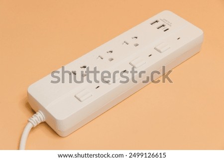 Electrical plug in outlet socket at home, Electrical plug in outlet socket at home, Energy efficiency concept, Power strip with extension cord on beige background, top view.