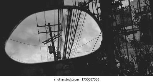 Electrical Post Being Reflected On A Motorcycle Side Mirror