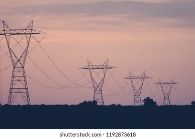 Electrical Power Lines Against A Purple Sunset Sky.