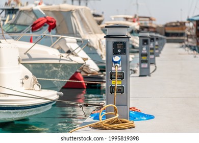 Electrical power sockets bollard on pier near sea coast. Charging station for boats in Mediterranean. Electrical outlets to charge ships in harbor.
