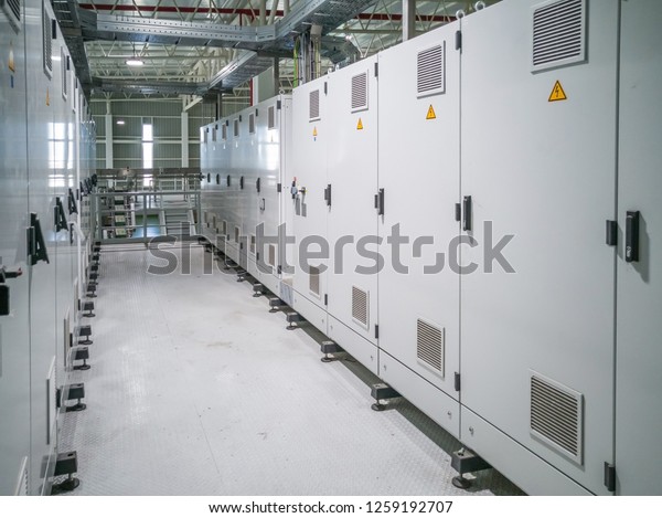 Electrical Room in a manufacturing factory\
industry. Electric wires, cabinets,\
servers.