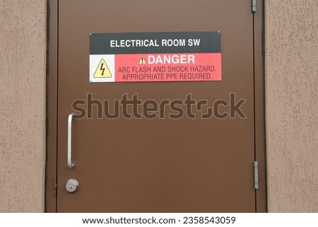 electrical room sw danger arc flash and shock hazard appropriate ppe required sign on brown metal entrance door with handle