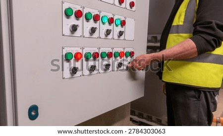 Electrical service engineer testing control panel faults in an HVAC control cabinet . Electrician fault finding on air conditioning and ventilation control circuits.