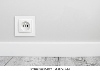 Electrical socket isolated on gray wall. Renovated studio apartment power supply background. Empty copy space single white plastic power outlet. - Shutterstock ID 1858734133