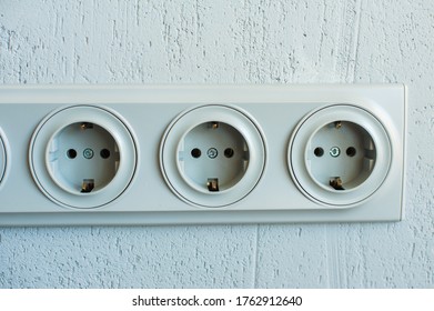 Electrical sockets on a gray wall, close-up
