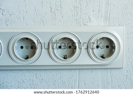 Electrical sockets on a gray wall, close-up