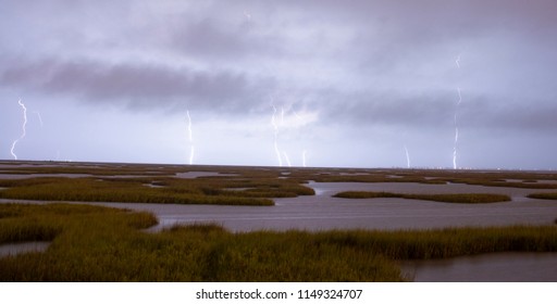 An Electrical Storm Approaches From Galveston Texas With Gulf Coast Marsh In The Foreground