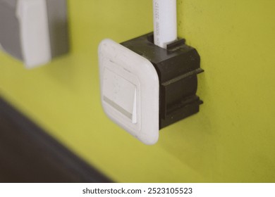 electrical switch on a wall, hand touches the switch
