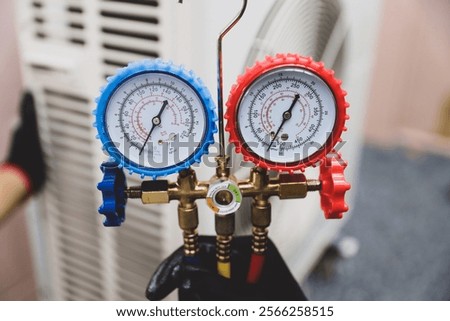 Electrical technician conditioning using manifold gauge measuring tool checking refrigerant pump filling home air conditioner and maintenance heat fix repair and clean outdoor air compressor unit.