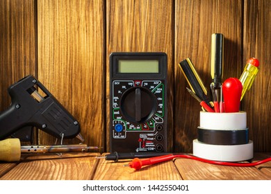 Electrical Tester And A Set Of Tools For Electronics Repair On Vintage Wooden Background.