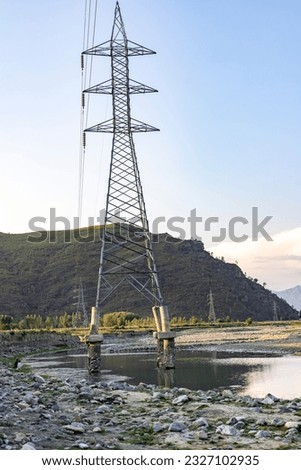 Electrical tower stands after heavy field washout the soil from its base pillars.