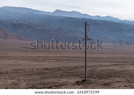 Electrical towers supporting high voltage power lines in the mountainous areas of Kyrgyzstan. Power transmission line in  the mountains.Electrification