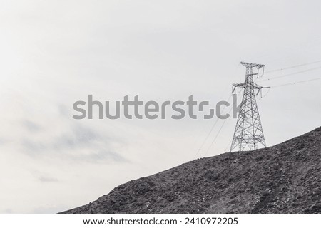 
Electrical towers supporting high voltage power lines in the mountainous areas of Kyrgyzstan. Power transmission line in a hard-to-reach place in the mountains, construction technologies.