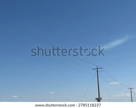 Electrical utility infrastructure and overhead power lines against clear blue sky showing public energy distribution network and outdoor utility systems