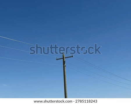 Electrical utility infrastructure and overhead power lines against clear blue sky showing public energy distribution network and outdoor utility systems