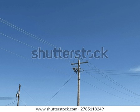 Electrical utility infrastructure and overhead power lines against clear blue sky showing public energy distribution network and outdoor utility systems