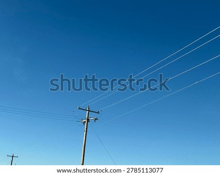 Electrical utility infrastructure and power distribution lines against clear blue sky showing public energy network and outdoor utility systems