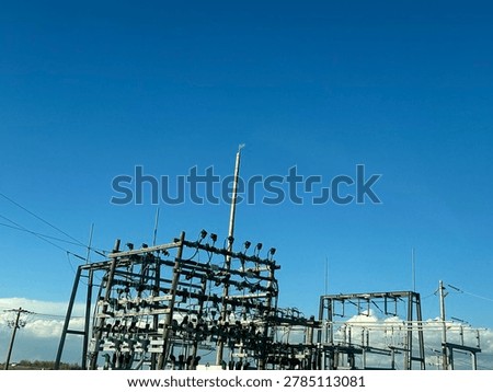 Electrical utility infrastructure and power distribution lines against clear blue sky showing public energy network and outdoor utility systems